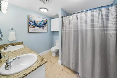 a bathroom with a shower and a sink and a toilet at 2206E Calypso Direct Gulffront Brand new remodel in Panama City Beach