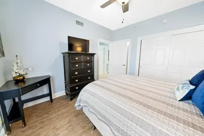 a bedroom with a bed and a desk and a television at 2206E Calypso Direct Gulffront Brand new remodel in Panama City Beach