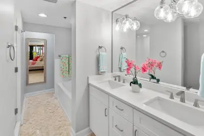 a white bathroom with two sinks and a large mirror at Grand Panana 106 in Panama City Beach