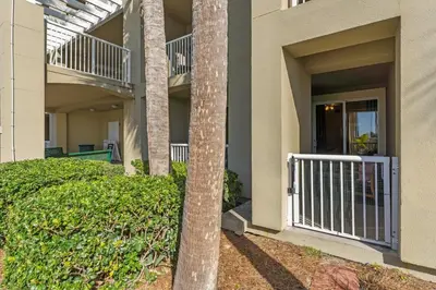 a building with a palm tree in the courtyard at Grand Panana 106 in Panama City Beach