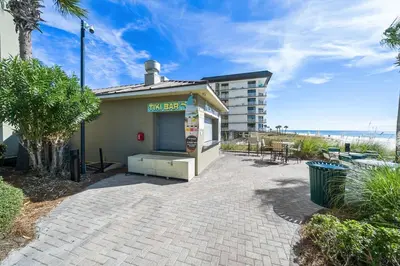 a building with a pizza shack next to a beach at Grand Panana 106 in Panama City Beach