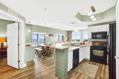 a kitchen with green walls and white cabinets at Calypso 2201E 3BR 3BA corner unit 2 sets of beach chairs in Panama City Beach