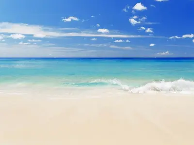 a sandy beach with the ocean in the background at Calypso 2201E 3BR 3BA corner unit 2 sets of beach chairs in Panama City Beach