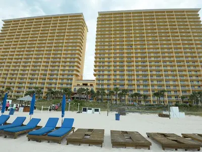 two large buildings with beach chairs and a hotel at Calypso 2201E 3BR 3BA corner unit 2 sets of beach chairs in Panama City Beach