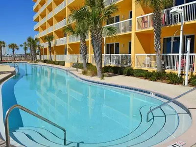 a large swimming pool in front of a hotel at Calypso 2201E 3BR 3BA corner unit 2 sets of beach chairs in Panama City Beach