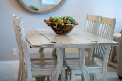 a wooden table with two chairs and a plant on it at Calypso 2006W Gulf Front and Newly renovated Custom Shower in Panama City Beach