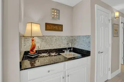 a kitchen with a sink and a lamp on a counter at Calypso 2006W Gulf Front and Newly renovated Custom Shower in Panama City Beach
