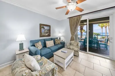 a living room with a blue couch and a table at Grand Panama 207 in Panama City Beach
