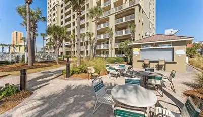 a patio with a table and chairs in front of a building at Grand Panama 207 in Panama City Beach