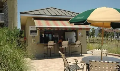 a restaurant with a table and chairs and an umbrella at Grand Panama 407 in Panama City Beach