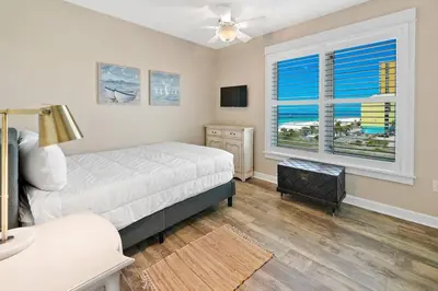 a bedroom with a bed and a television and a window at Grand Panama 501 in Panama City Beach