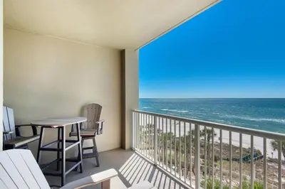 a balcony with a table and chairs and the ocean at Grand Panama 604 in Panama City Beach