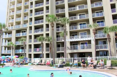 a hotel with a swimming pool and people in a resort at Grand Panama 604 in Panama City Beach