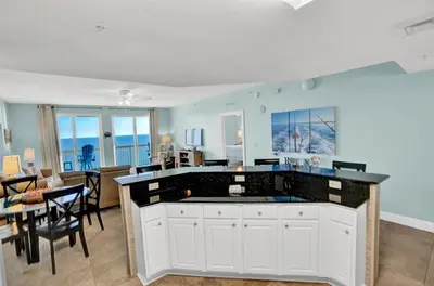 a living room with a kitchen and a dining room at Calypso 1601W Gulf Front Corner unit Fantastic Specials in Panama City Beach