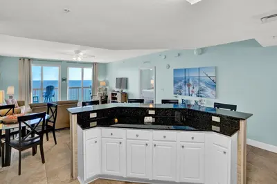 a kitchen and dining room with a view of the ocean at Calypso 1601W Gulf Front Corner unit Fantastic Specials in Panama City Beach