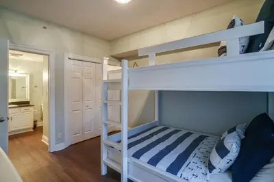 a bedroom with two bunk beds and a bathroom at Calypso 1401E 3BR 3BA Corner unit Direct Gulf Front High Demand in Panama City Beach