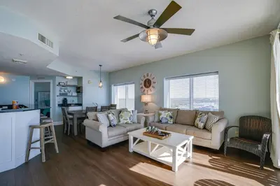 a living room with a couch and a ceiling fan at Calypso 1401E 3BR 3BA Corner unit Direct Gulf Front High Demand in Panama City Beach