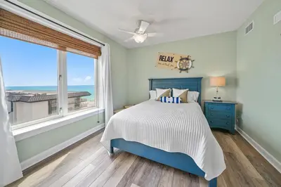a bedroom with a bed and a large window at Grand Panama 809 in Panama City Beach