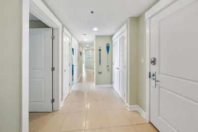 a hallway with white doors and a tile floor at Grand Panama 809 in Panama City Beach