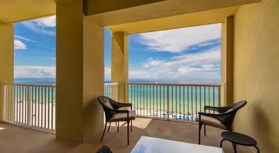 a balcony with two chairs and a view of the ocean at Grand Panama 809 in Panama City Beach