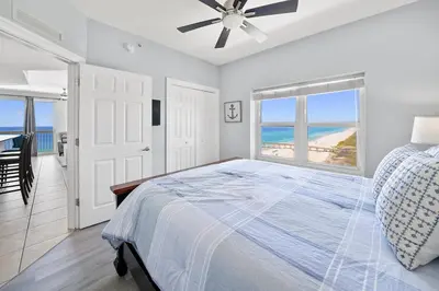 a bedroom with a bed with a view of the ocean at Calypso 1209W Corner 3BR 3BA 2 sets of beach service in Panama City Beach