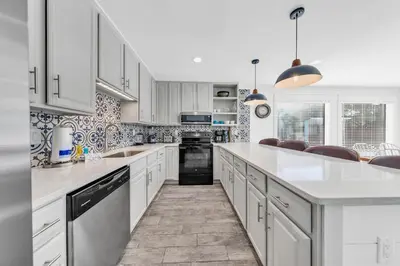 a kitchen with white cabinets and white counter tops at Tiki Palms Paradise by Emerald Coast Retreats in Panama City Beach
