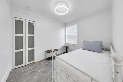 a white bedroom with a bed and a window at Tiki Palms Paradise by Emerald Coast Retreats in Panama City Beach