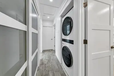 a hallway with a washer and dryer in a house at Tiki Palms Paradise by Emerald Coast Retreats in Panama City Beach