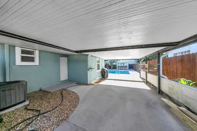 an empty garage with a building with a fence at Tiki Palms Paradise by Emerald Coast Retreats in Panama City Beach