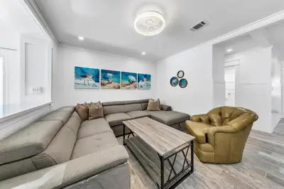 a living room with a couch and a table at Tiki Palms Paradise by Emerald Coast Retreats in Panama City Beach