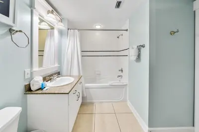 a white bathroom with a sink and a toilet at Grand Panama 902 in Panama City Beach