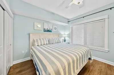 a bedroom with a bed with a striped blanket at Grand Panama 902 in Panama City Beach