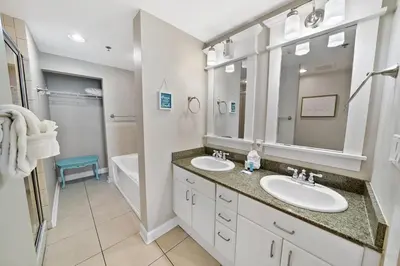 a bathroom with two sinks and a large mirror at Grand Panama 904 in Panama City Beach
