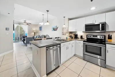 a kitchen with white cabinets and a stove top oven at Grand Panama 904 in Panama City Beach