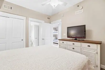 a bedroom with a bed and a flat screen tv at Grand Panama 1003 in Panama City Beach