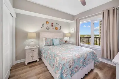 a bedroom with a bed and a balcony at Grand Panama 1204 in Panama City Beach