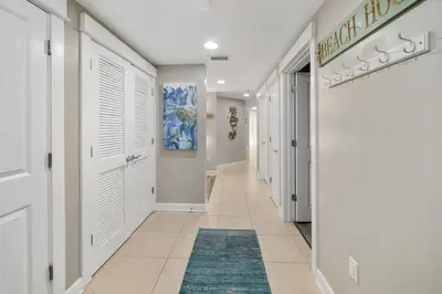 a hallway with white doors and a blue rug at Grand Panama 1204 in Panama City Beach