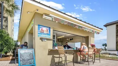 a group of people sitting at a restaurant at Grand Panama 1307 in Panama City Beach