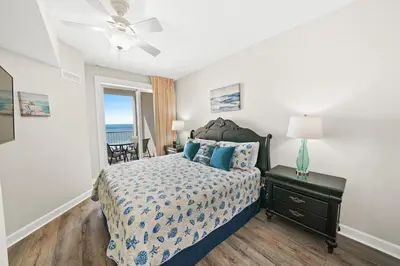 a bedroom with a bed with a view of the ocean at Grand Panama 1405 in Panama City Beach