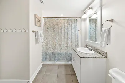 a white bathroom with a sink and a window at Grand Panama 1405 in Panama City Beach