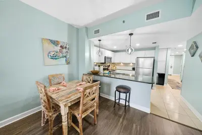 a kitchen and dining room with a table and chairs at Grand Panama 1406 in Panama City Beach