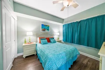 a bedroom with a bed with blue walls and a ceiling at Grand Panama 1406 in Panama City Beach
