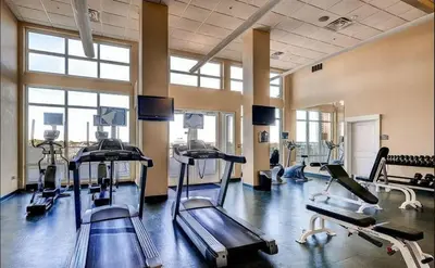a gym with several tread machines in a room at Grand Panama 1406 in Panama City Beach