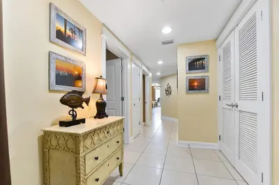 a hallway with a dresser with a lamp on it at Grand Panama 1408 in Panama City Beach