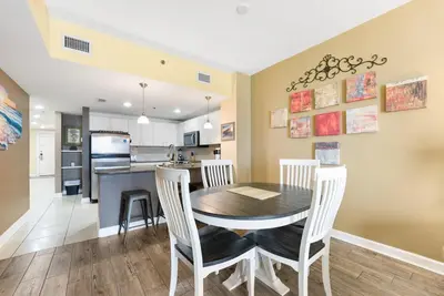 a dining room and kitchen with a table and chairs at Grand Panama 1408 in Panama City Beach