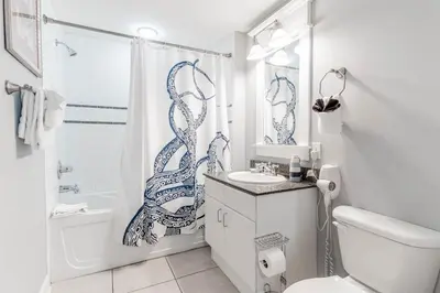 a bathroom with a shower curtain with a fish drawn on it at Grand Panama 1508 in Panama City Beach