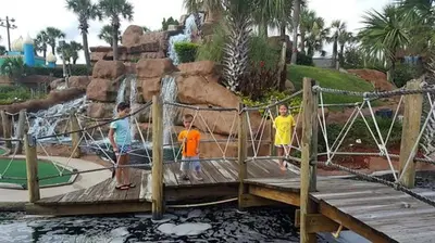 three children standing on a bridge in a water park at Grand Panama 1508 in Panama City Beach