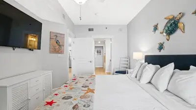 a bedroom with a bed and a tv on the wall at Grand Panama 1801 in Panama City Beach