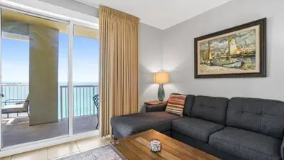 a living room with a couch and a balcony at Grand Panama 1801 in Panama City Beach