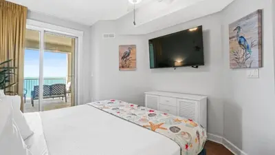 a bedroom with a bed and a flat screen tv at Grand Panama 1801 in Panama City Beach